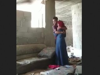 A couple engages in intimate activities at a building site with a hidden observer