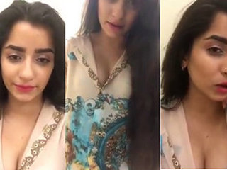 A charming South Asian woman fondles her alluring breasts while engaging in conversation with her admirers