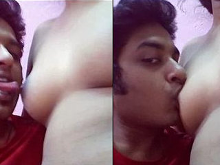 A guy pleasuring his girlfriend's breasts