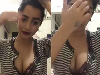 A charming young woman with alluring breasts engages in conversation with her admirers