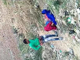 Desi girl moans loudly as she has sex with a man in the bushes, while another records it